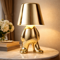 Luxury Gold Table Lamp - Aurelio with sculptural humanoid base and warm glow, perfect for elegant interiors and modern home decor.