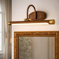 Luxury Wooden LED Wall Light with brass accents mounted above ornate mirror. Premium LED lighting fixture for elegant home décor and warm ambiance.