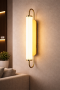 Aureline Luxury LED Wall Sconce mounted on a modern interior wall, featuring a sleek gold frame and soft ambient lighting. Ideal for upscale home décor.