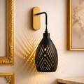 Luxury wall sconce lighting with black matte finish and gold interior, casting artistic shadows. Ideal for elegant interiors and designer illumination.