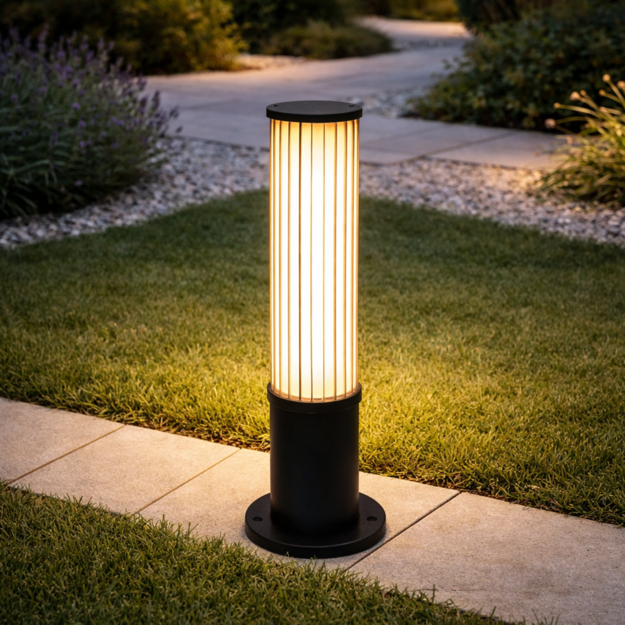 GlowColumn outdoor bollard light with LED illumination, installed along a modern garden pathway. Durable and elegant design for landscape lighting.