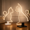 Artistic LED Cat Table Lamp in black and white bases with glowing cat silhouette design, perfect for modern home ambiance and cozy lighting.